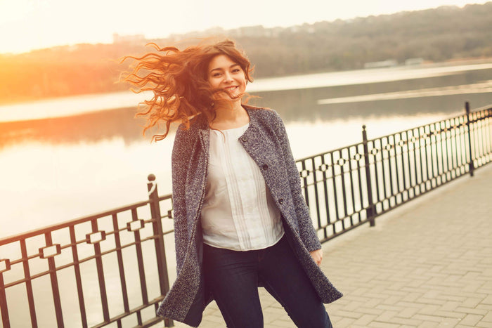 women smiles in front of a lake