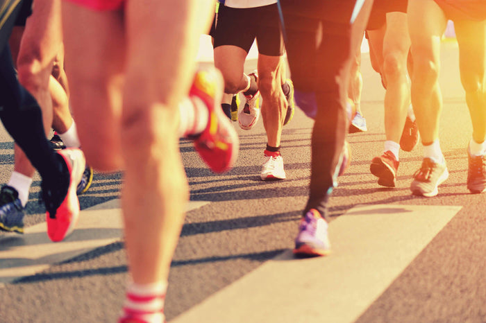 a group of runners race down a road together